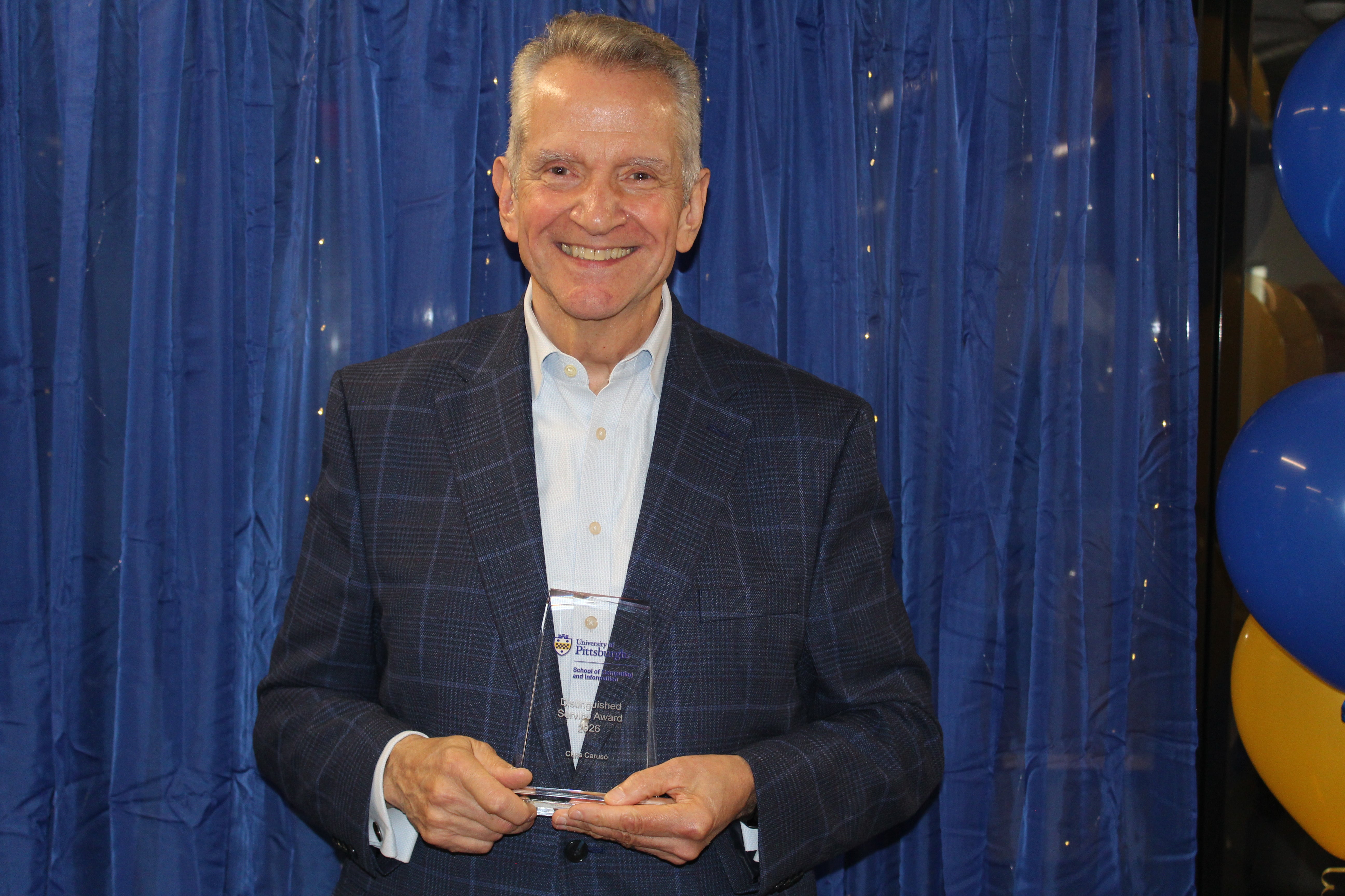 Chris Caruso holding his Distinguished Service Award
