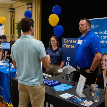 student asking question at info table