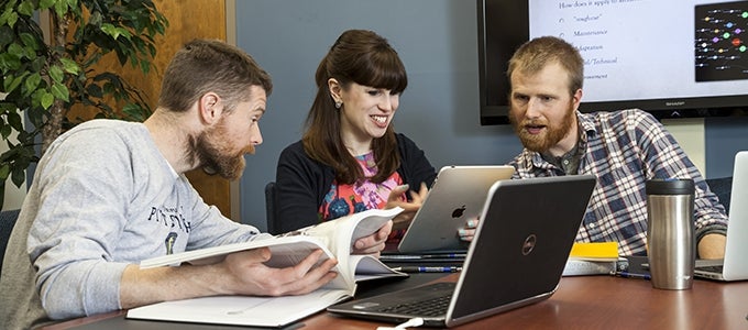 three people looking at ipad