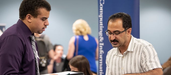 two men looking at papers