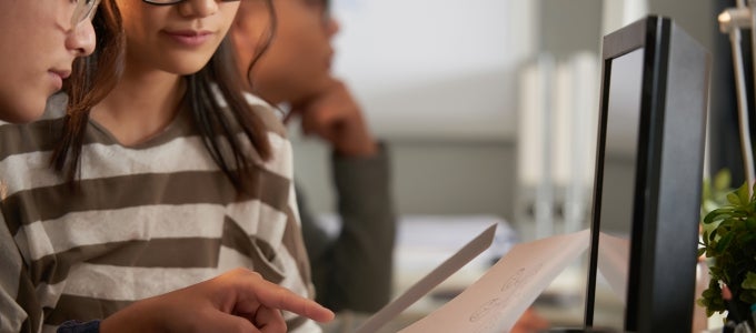 female students looking at paper