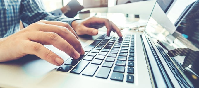 hands typing on laptop keyboard