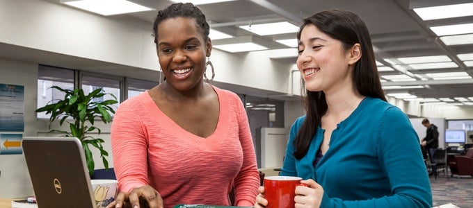 two female students working on laptop