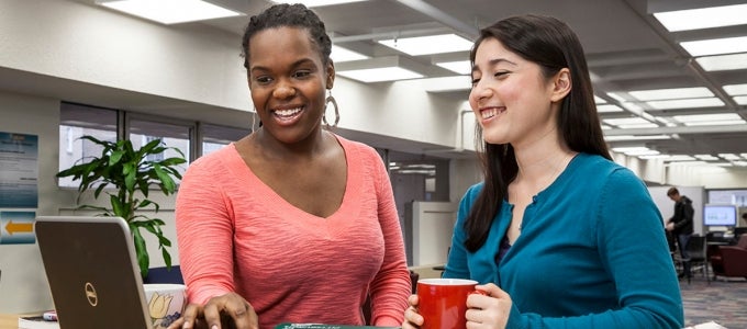 two female students working on laptop