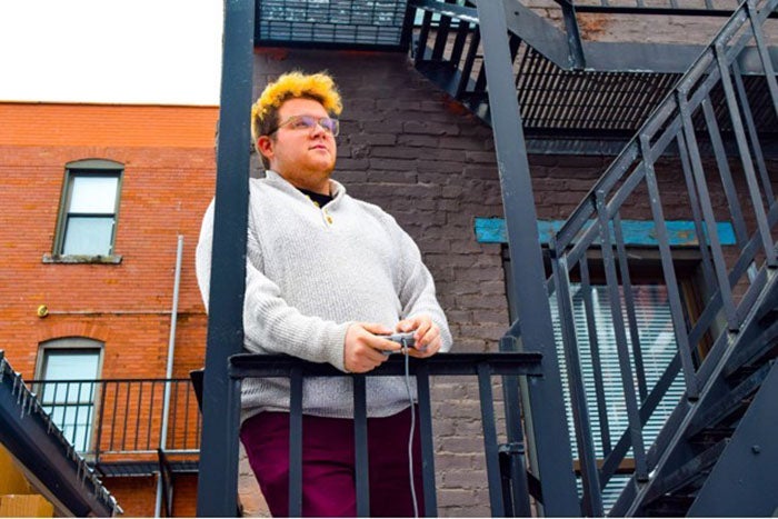 Pat Healy with a device in hand standing on the steps to a building