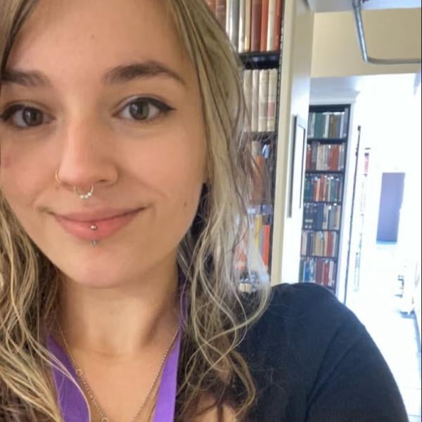 Photo of Carlee Stoner in front of book shelves