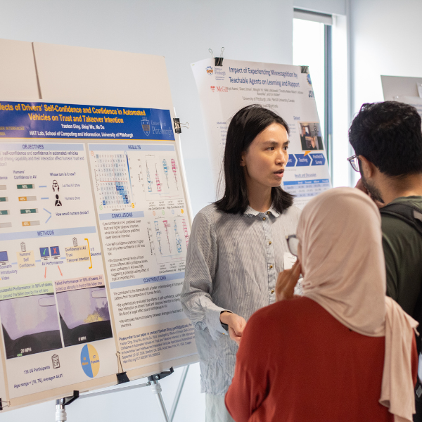 Student presents her work in front of a research poster