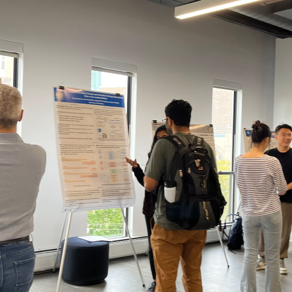 guy viewing a research poster that is standing on an easel