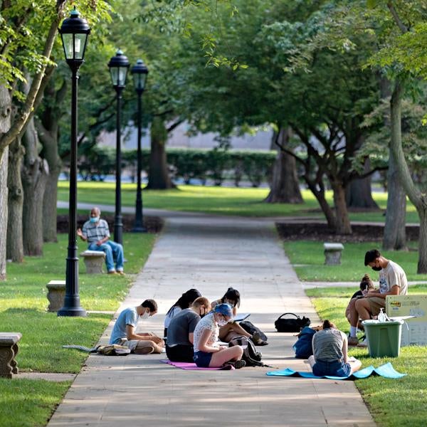 Students sitting on Cathedral sidewalk
