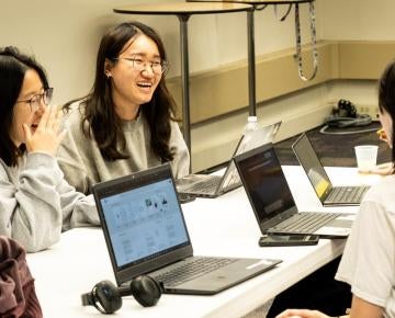 Three female students laugh together