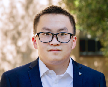 man wearing glasses with suit outside