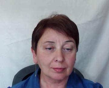 woman with short brown hair in front of white curtain