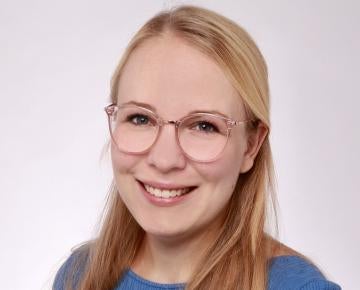 woman with long blond hair wearing glasses