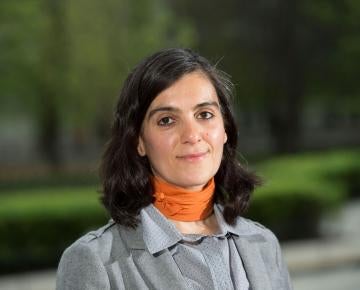 A woman wearing an orange scarf and gray shirt