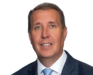 man wearing suit and a sky blue tie in front of a white background