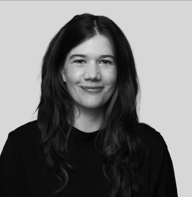 black and white photo of person with long hair wearing a dark sweater