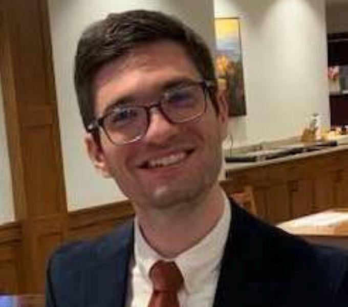 man in glasses wearing suit with red tie