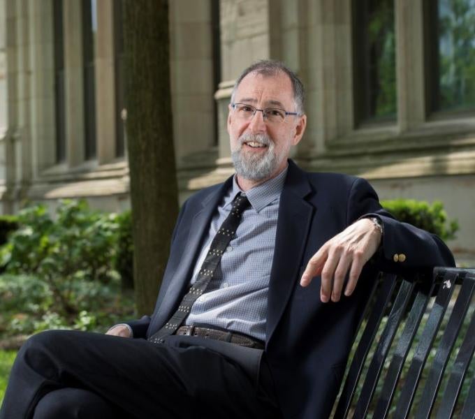 Photo of Paul Cohen sitting on a bench outside