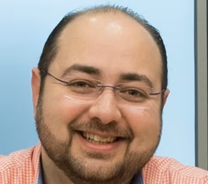 man wearing glasses and salmon-colored shirt
