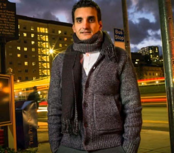 man wearing scarf and jacket outside at night
